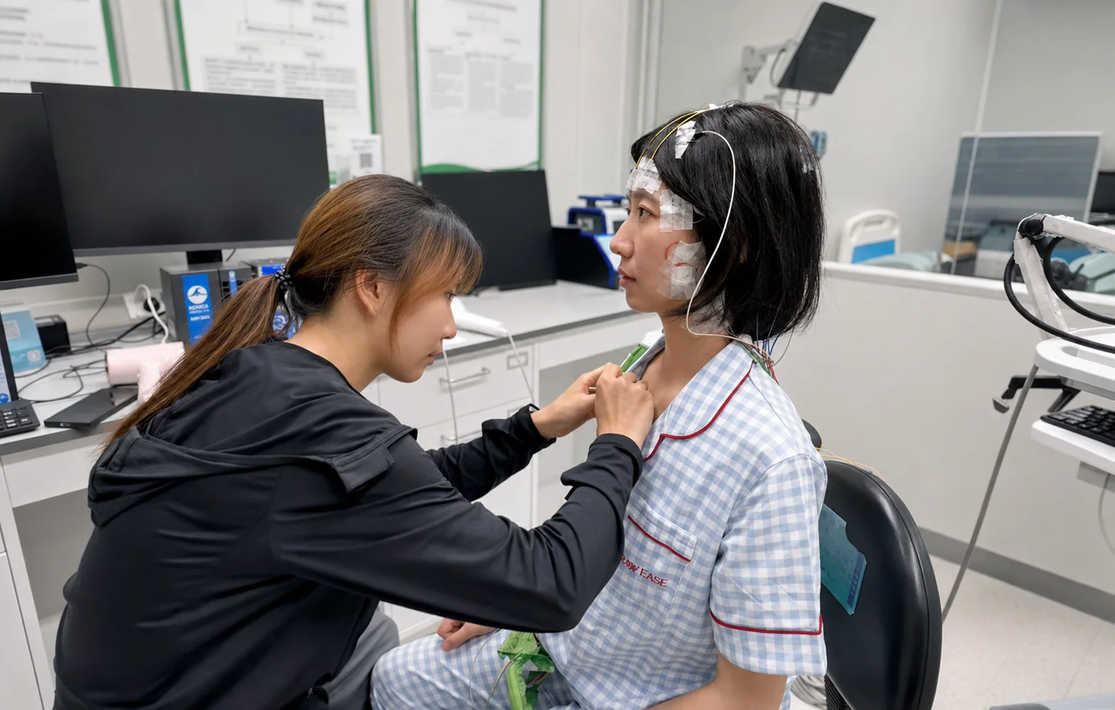 A technician attaches a chest lead to a seated PSG participant
